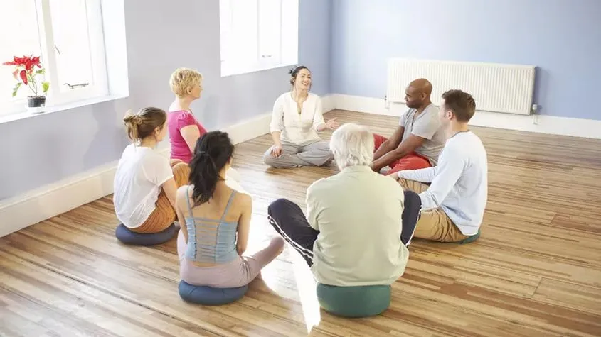 group of seven people sitting in a circle